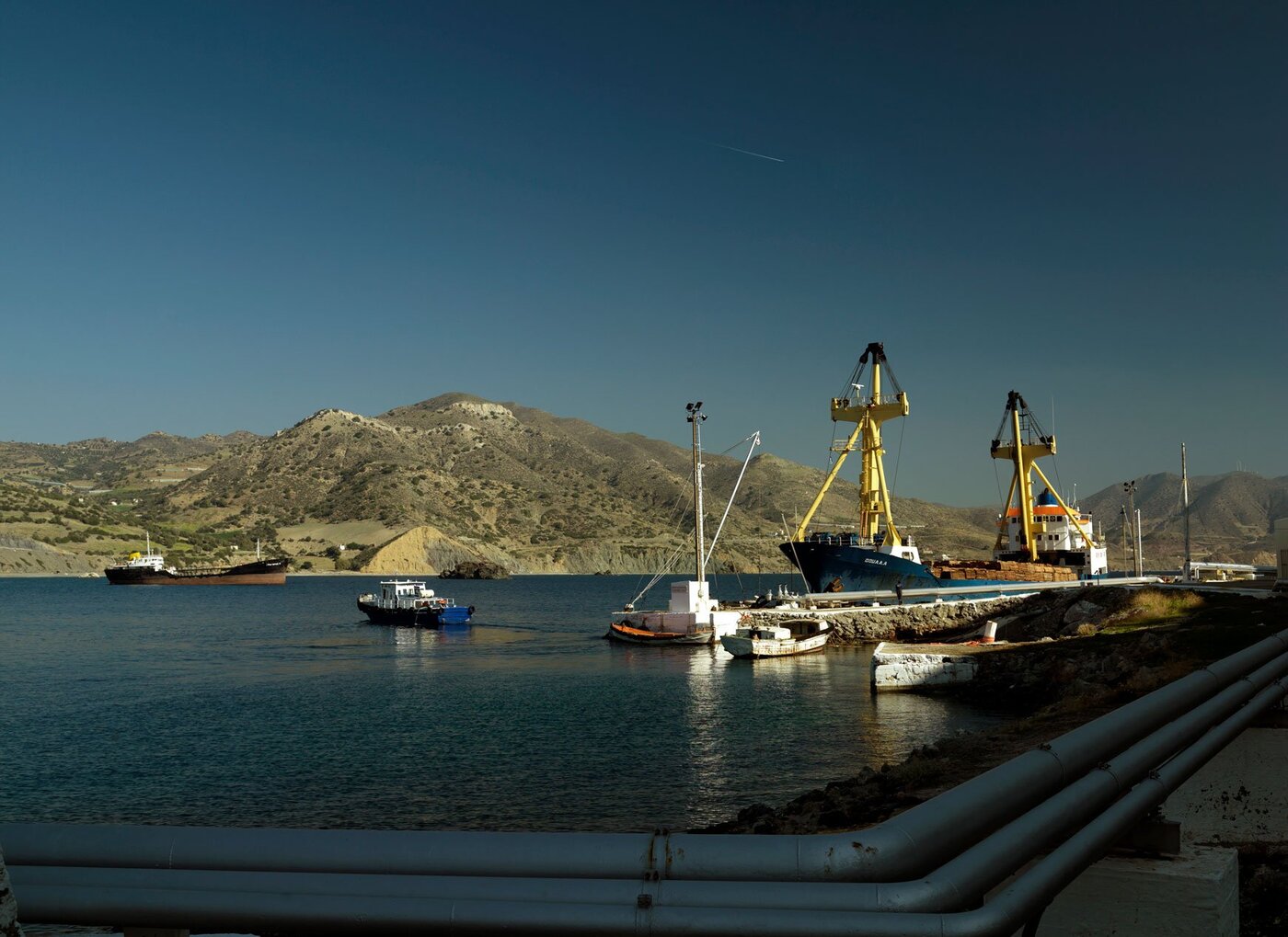 Greek port with pipelines and cargo cranes