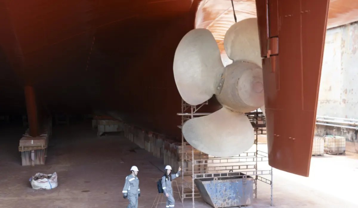 Propeller and rudder of a vessel in dry dock at Elefsina Shipyard with engineers alongside